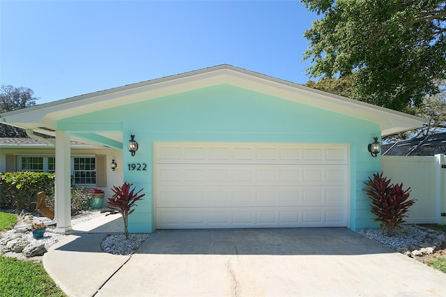 view of front of property with concrete driveway, fence, and a garage