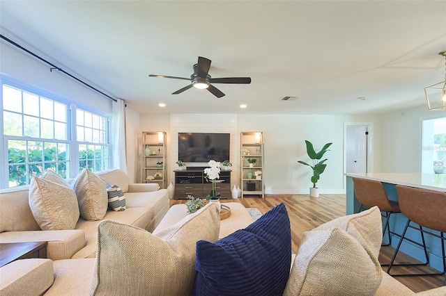 living room with visible vents, baseboards, ceiling fan, light wood-type flooring, and recessed lighting