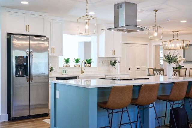 kitchen with stovetop, island exhaust hood, stainless steel fridge, white cabinetry, and tasteful backsplash