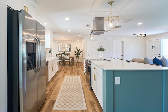 kitchen with white cabinetry, light wood finished floors, island exhaust hood, and appliances with stainless steel finishes