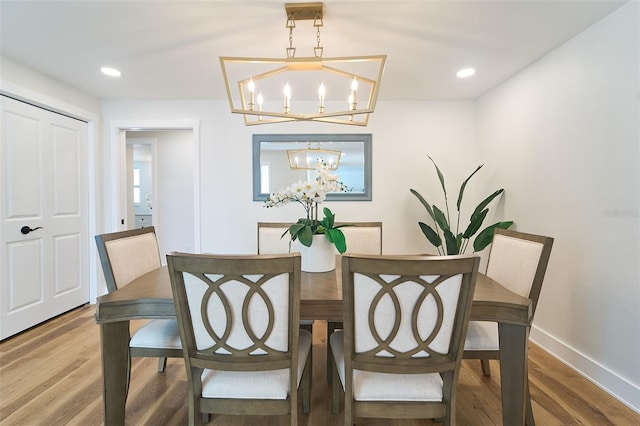 dining space with recessed lighting, baseboards, wood finished floors, and a chandelier