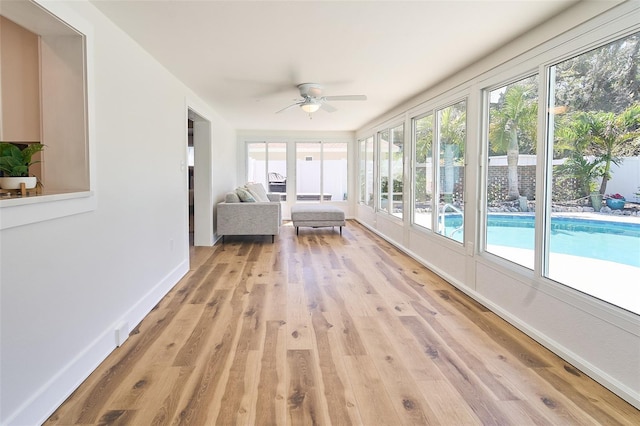 unfurnished sunroom featuring ceiling fan