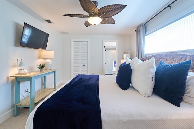 carpeted bedroom featuring baseboards, visible vents, ceiling fan, a closet, and connected bathroom