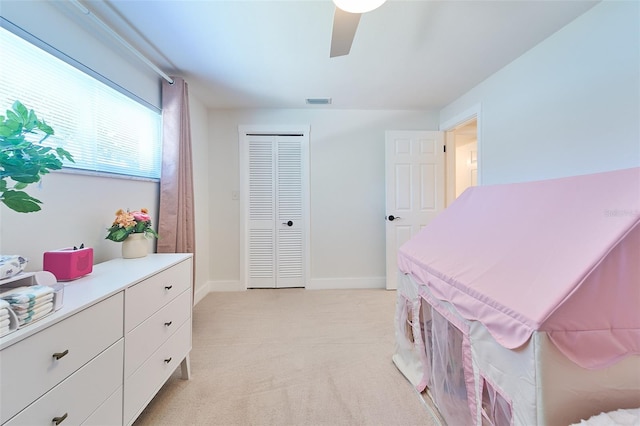 bedroom with visible vents, baseboards, light colored carpet, and a ceiling fan