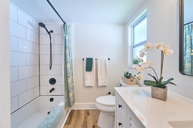 bathroom with baseboards, toilet, shower / bath combo, wood finished floors, and vanity