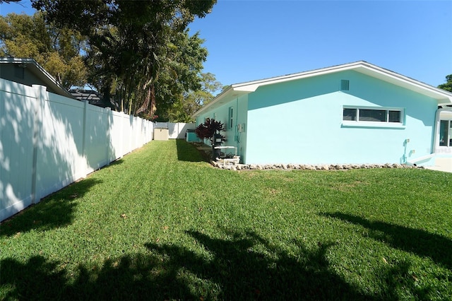 view of home's exterior featuring a lawn, a fenced backyard, and stucco siding