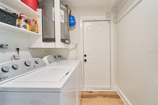 laundry room featuring light wood finished floors, laundry area, independent washer and dryer, and baseboards