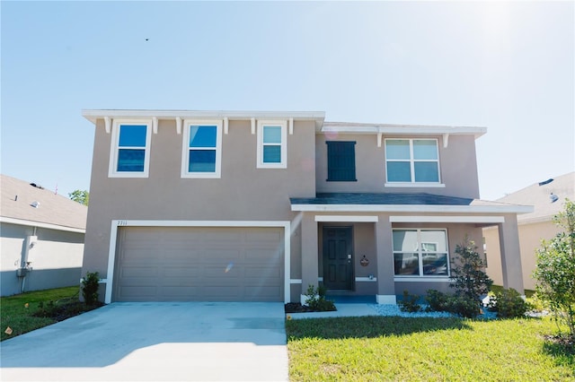 view of front of home featuring concrete driveway, a garage, a front yard, and stucco siding