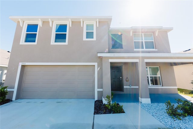 view of front of property featuring stucco siding, concrete driveway, and an attached garage