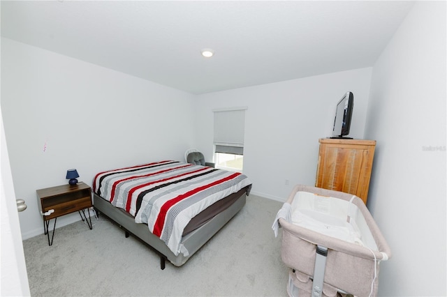 bedroom with light carpet and baseboards