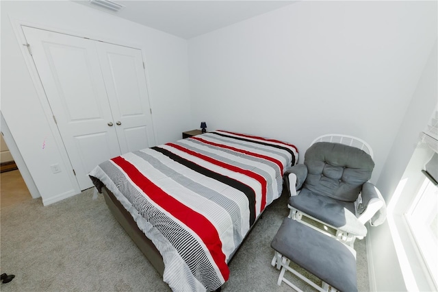 bedroom featuring visible vents, a closet, and light carpet