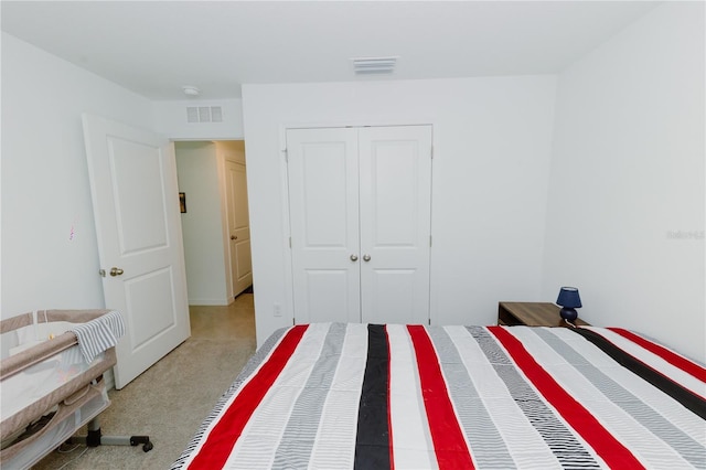 bedroom featuring visible vents, a closet, and light carpet