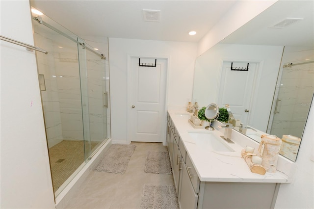 bathroom featuring a marble finish shower, visible vents, double vanity, and a sink