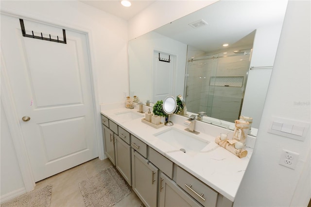 full bathroom featuring double vanity, visible vents, a shower stall, and a sink