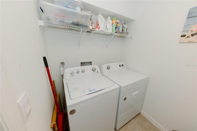 laundry room with laundry area, light tile patterned floors, separate washer and dryer, and baseboards