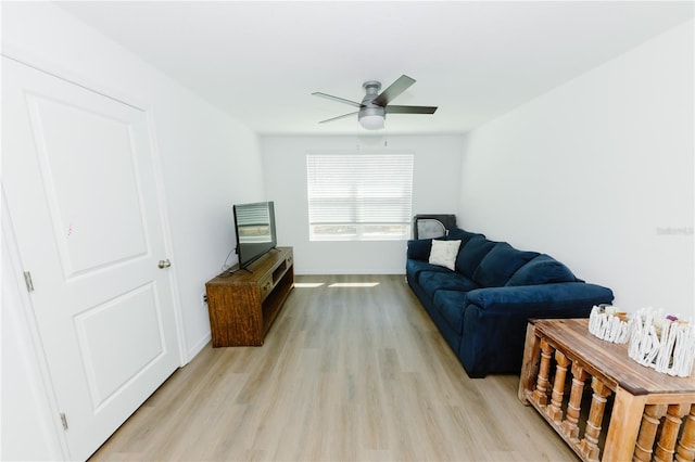 living room featuring light wood-style flooring, baseboards, and ceiling fan