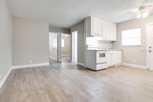 kitchen with backsplash, baseboards, under cabinet range hood, light wood-type flooring, and electric range