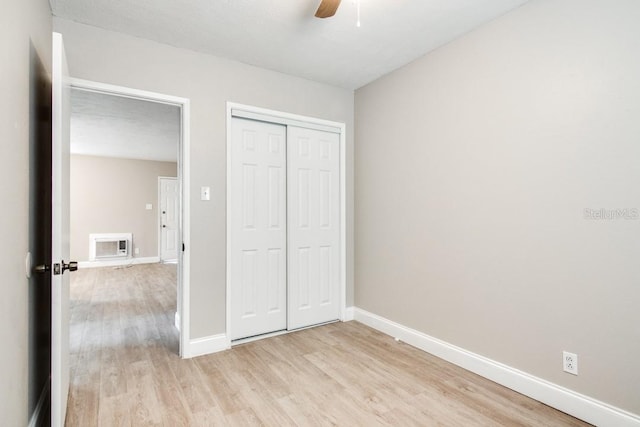 unfurnished bedroom with a ceiling fan, baseboards, a closet, and light wood finished floors