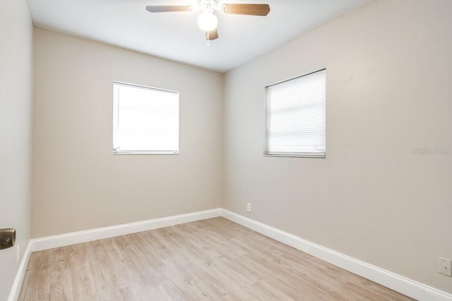 spare room featuring a ceiling fan, wood finished floors, and baseboards