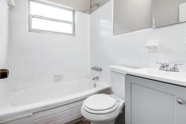 bathroom featuring vanity, toilet, tile walls, and  shower combination