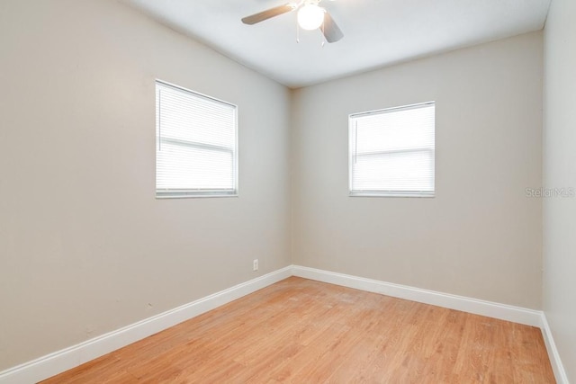 unfurnished room featuring plenty of natural light, baseboards, light wood finished floors, and ceiling fan