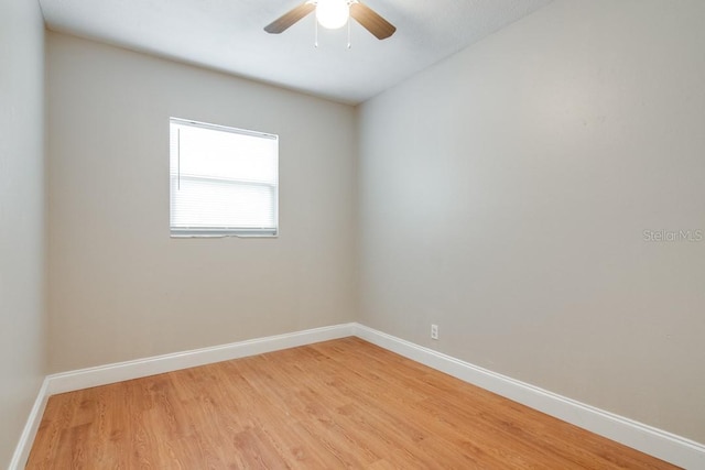 empty room with light wood-style flooring, a ceiling fan, and baseboards