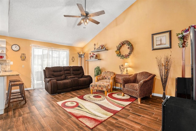 living area featuring wood finish floors, a ceiling fan, a textured ceiling, baseboards, and vaulted ceiling