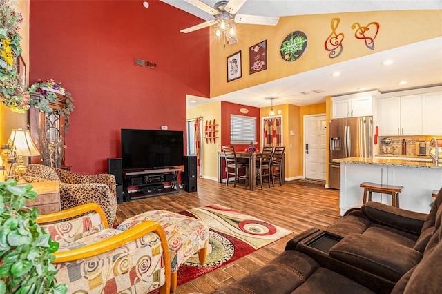 living area with visible vents, high vaulted ceiling, a ceiling fan, wood finished floors, and recessed lighting