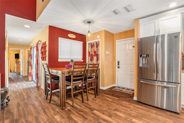 dining area featuring visible vents, baseboards, and wood finished floors