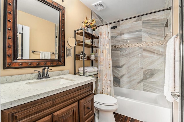 full bath with visible vents, toilet, shower / bath combo, wood finished floors, and vanity