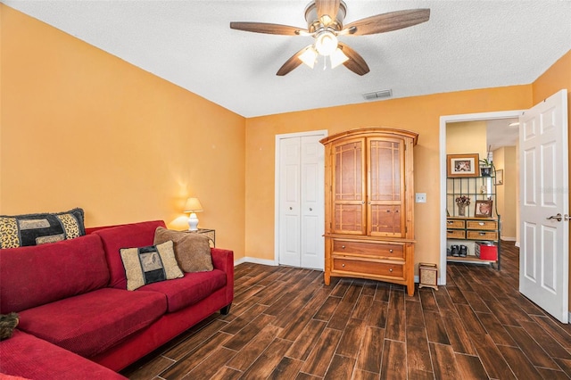 living room featuring visible vents, a textured ceiling, and wood tiled floor