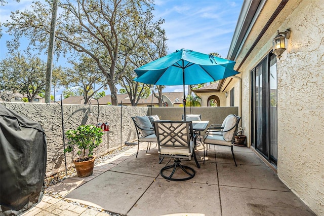 view of patio with outdoor dining space, a grill, and a fenced backyard