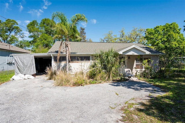 view of front of house featuring an attached carport and gravel driveway