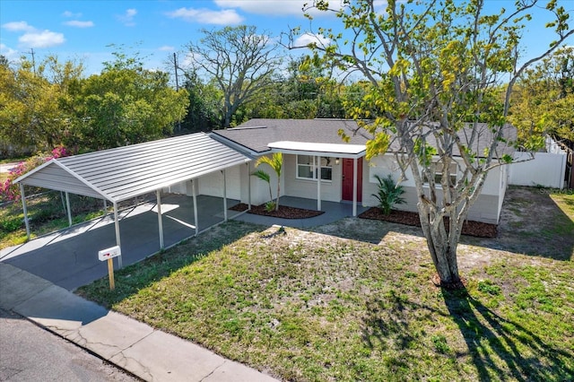 ranch-style house with a shingled roof, concrete driveway, a front lawn, and fence