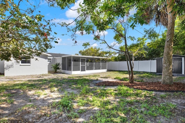 view of yard with fence and a sunroom