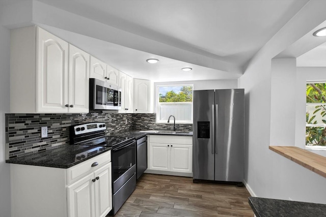 kitchen featuring a sink, stainless steel appliances, tasteful backsplash, and white cabinets