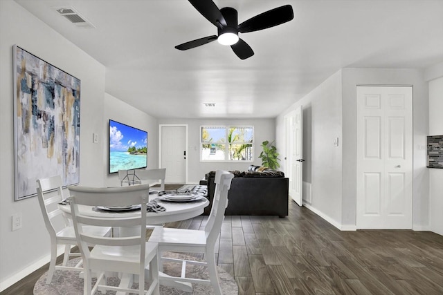 dining area featuring ceiling fan, visible vents, baseboards, and dark wood-style floors