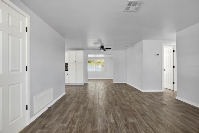 unfurnished room featuring dark wood-type flooring, baseboards, visible vents, and ceiling fan