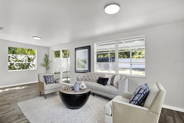 living room featuring a healthy amount of sunlight, baseboards, and wood finished floors