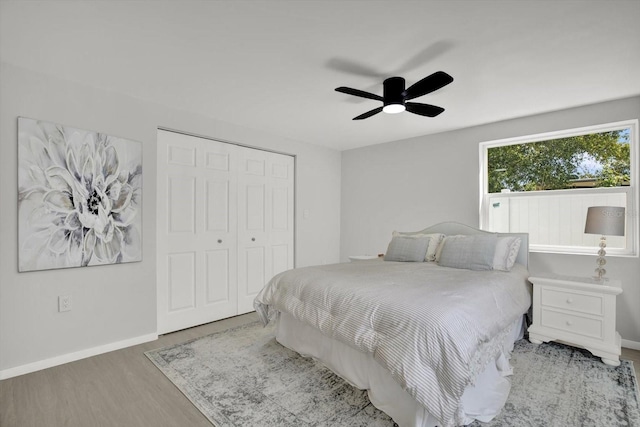 bedroom with ceiling fan, a closet, baseboards, and wood finished floors