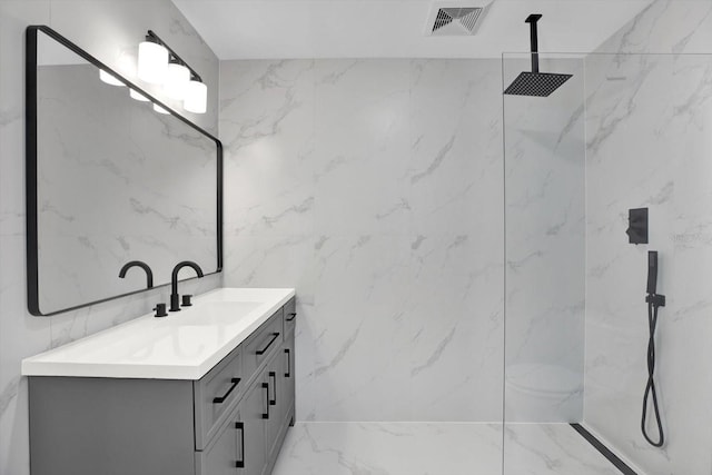 bathroom with vanity, visible vents, a marble finish shower, tile walls, and marble finish floor