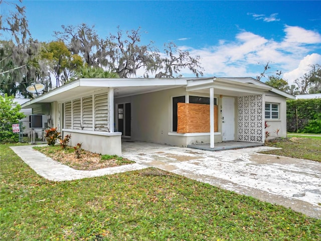 view of front of house with a carport, driveway, and a front lawn