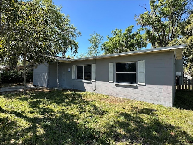 view of front of property featuring concrete block siding and a front yard