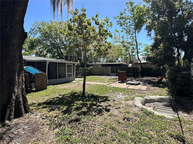 view of yard with a patio, fence, and a sunroom