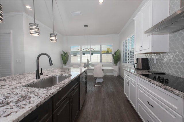 kitchen featuring dark wood-type flooring, black electric stovetop, wall chimney range hood, white cabinetry, and a sink