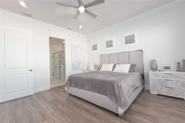 bedroom with visible vents, crown molding, baseboards, and wood finished floors