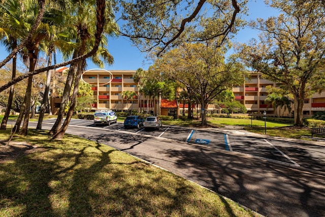 view of property's community with a lawn and uncovered parking