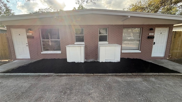 view of front of house with brick siding and fence