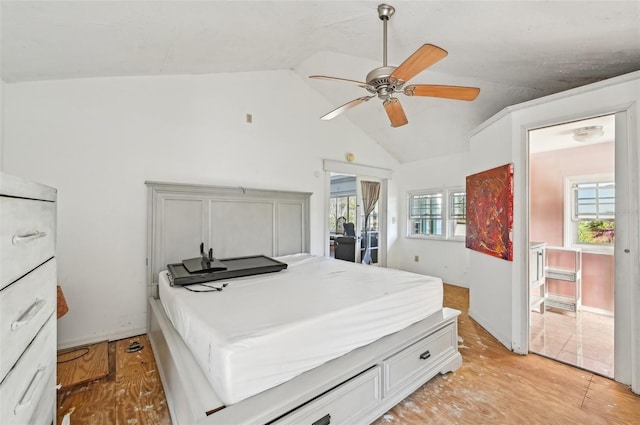 bedroom with light wood-type flooring, baseboards, and vaulted ceiling