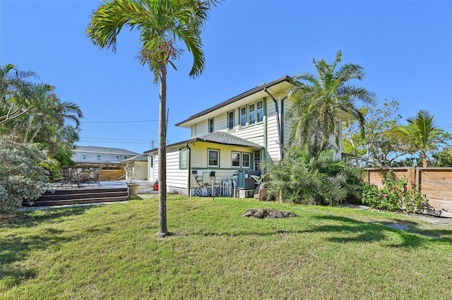 back of house with fence and a lawn